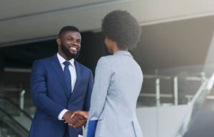 African american businessman shaking hands with his female partner celebrating successful teamwork.