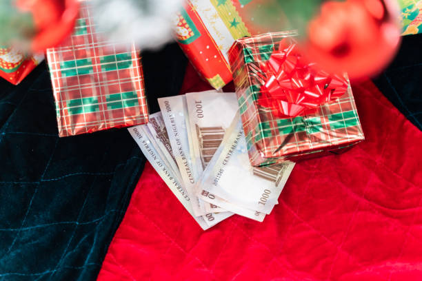 Nigerian Naira notes under Christmas Tree with wrapped presents and gifts