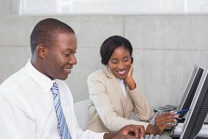 Young female employee helping her male colleague with work