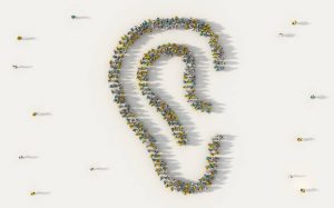 Large group of people forming an ear symbol in social media and community concept on white background. 3d sign of crowd illustration from above gathered together