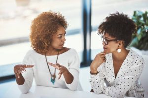 Shot of a female employee communicating with a colleague in a modern office