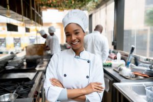 Portrait of a beautiful female chef working in a kitchen at a restaurant