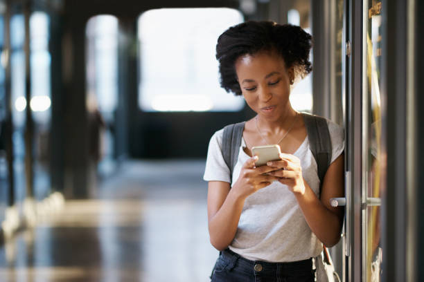 Shot of a young woman using a mobile phone at university