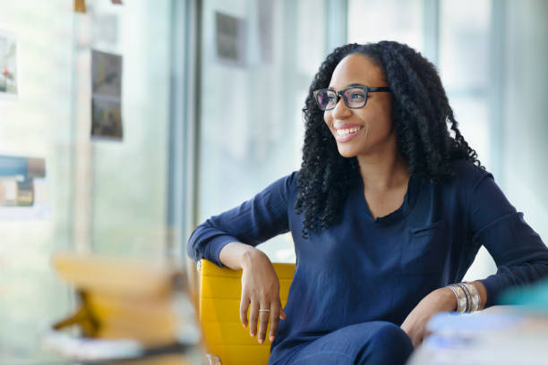 Portrait of young Black female professional sitting down and smiling in her office