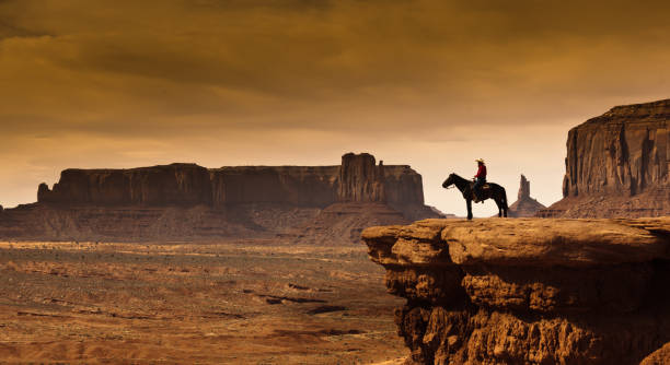 An Native American cowboy on horseback at the edge of a butte cliff. A backdrop for Western movies.