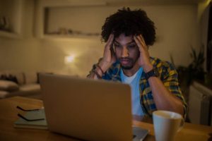 Young man looking stressed and anxious while working