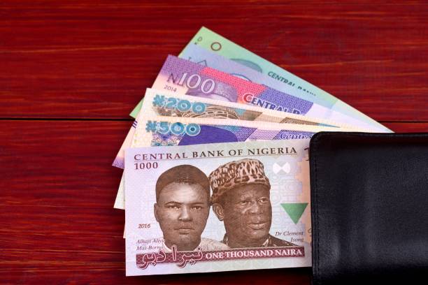 Nigerian Naira notes in the black wallet on a wooden background.