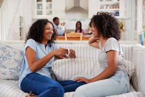 Mother Talking With Teenage Daughter On Sofa