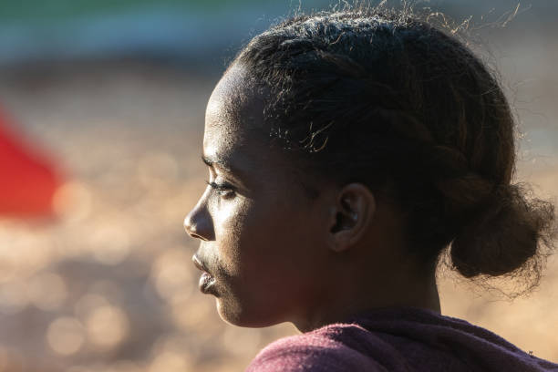 Backlit image of a serious beautiful young black woman looking away