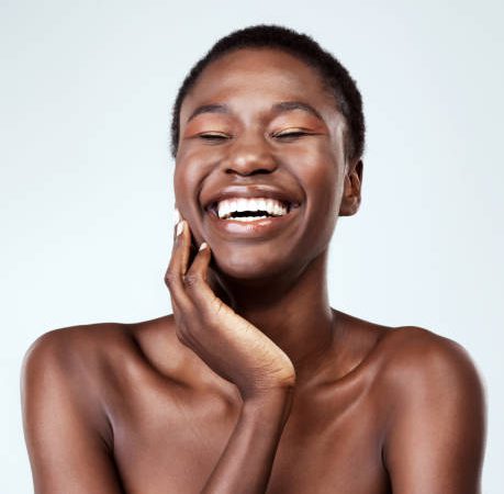 Studio shot of a beautiful young woman feeling her skin