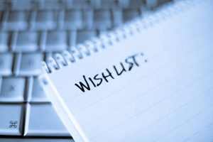 High key closeup of a blank notebook with 'wishlist' written on it.
