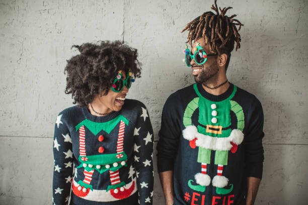 Young couple wearing festive holiday sweaters