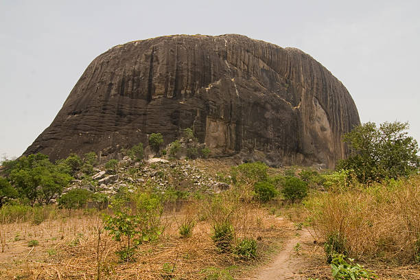 "Zuma Rock, a large monolith in Niger state close to Abuja. A face can be seen eroded in the rock at about a quarter of the rock from the right."