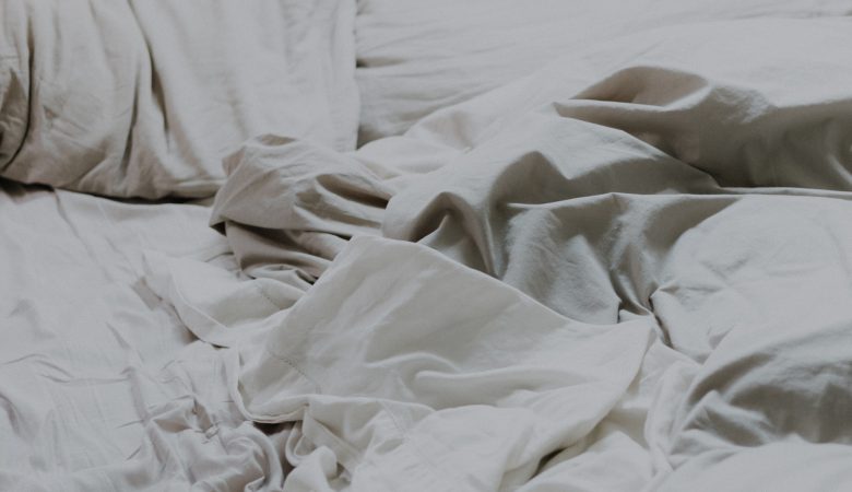 A scattered bed with white, rumpled sheets