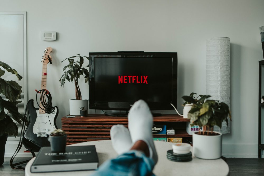 A photo of someone's feetin socks, in front of a TV screen